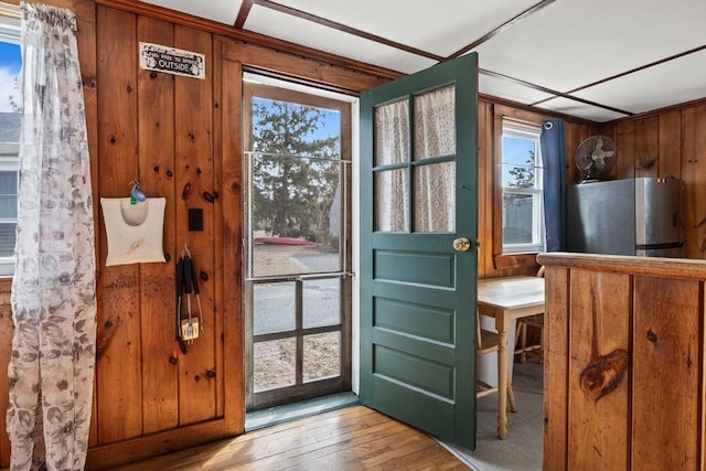 doorway to outside featuring hardwood / wood-style flooring and wooden walls