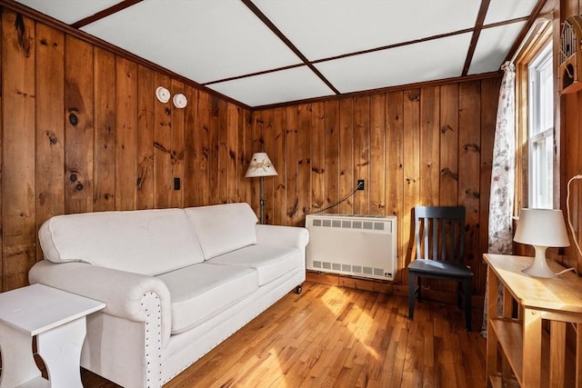 living room with wooden walls, hardwood / wood-style flooring, and radiator