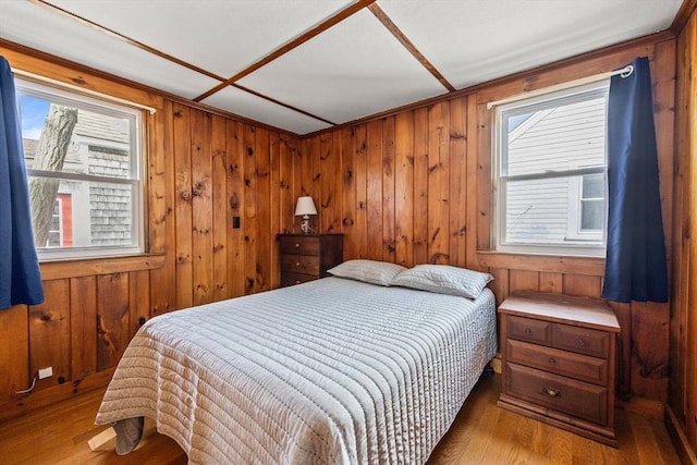 bedroom featuring wood walls and wood finished floors