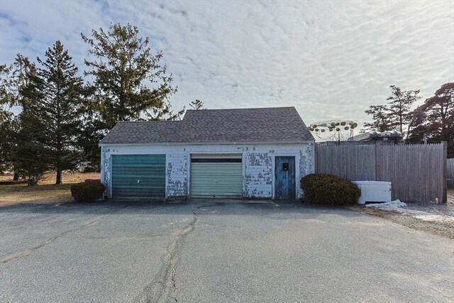 garage with fence and aphalt driveway