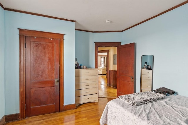 bedroom featuring crown molding, baseboards, and light wood-type flooring