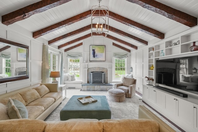 living room with lofted ceiling with beams, a stone fireplace, built in shelves, and wooden ceiling