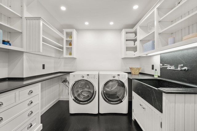 laundry area featuring dark wood-type flooring, washer and dryer, and cabinets