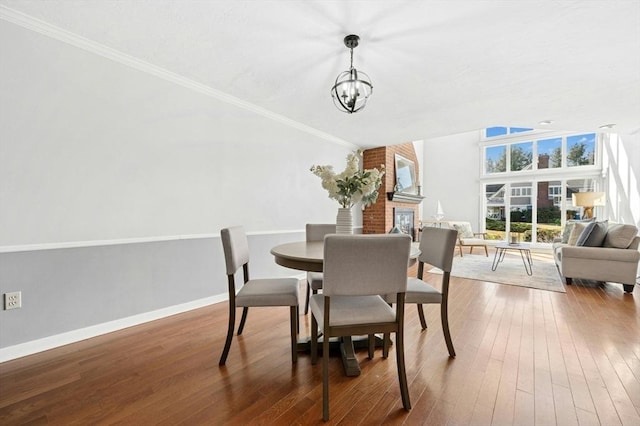dining room with an inviting chandelier, hardwood / wood-style flooring, baseboards, and ornamental molding