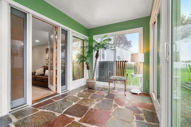 sunroom / solarium with recessed lighting and stone floors