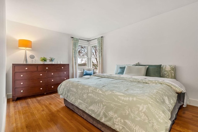 bedroom featuring baseboards and wood finished floors