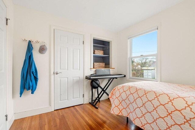 bedroom featuring wood finished floors and baseboards