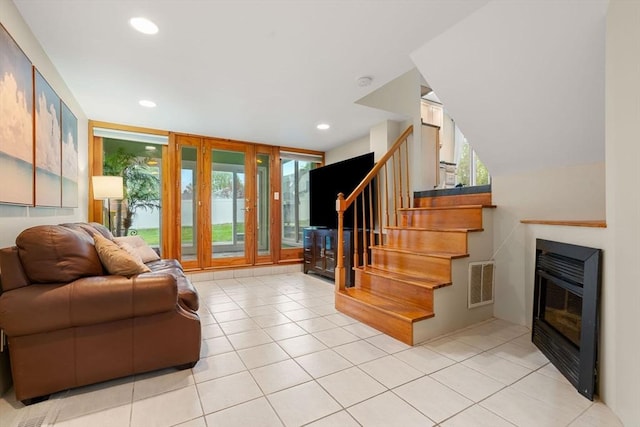 living room with recessed lighting, visible vents, light tile patterned flooring, stairs, and a fireplace