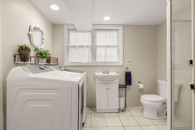 clothes washing area featuring washer and dryer, laundry area, light tile patterned floors, and a sink
