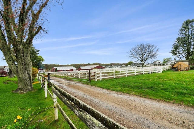view of street with a rural view, a gated entry, and driveway