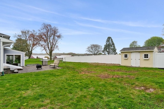 view of yard with a patio area, an outdoor structure, a fire pit, and fence