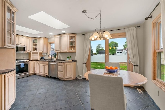 kitchen with stainless steel appliances, dark countertops, and a healthy amount of sunlight