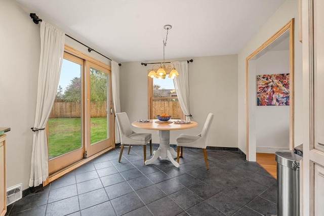 dining room featuring plenty of natural light, a chandelier, baseboards, and visible vents