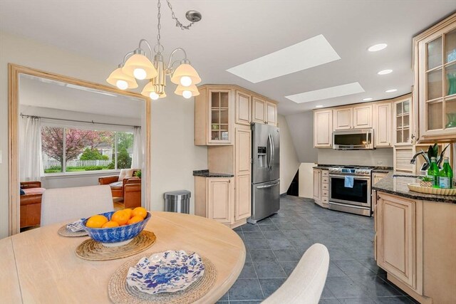 kitchen with recessed lighting, a sink, a skylight, appliances with stainless steel finishes, and cream cabinets