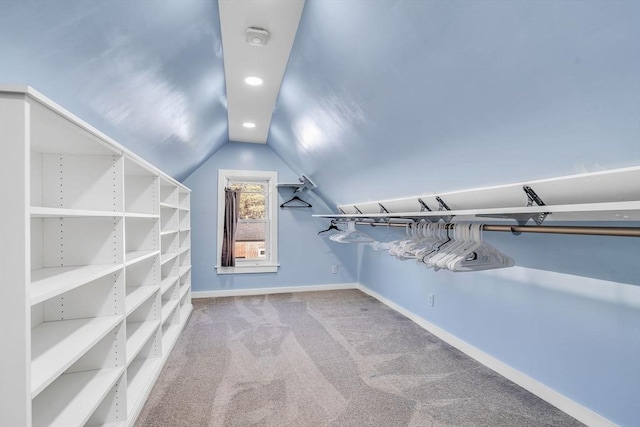 walk in closet with carpet floors and vaulted ceiling