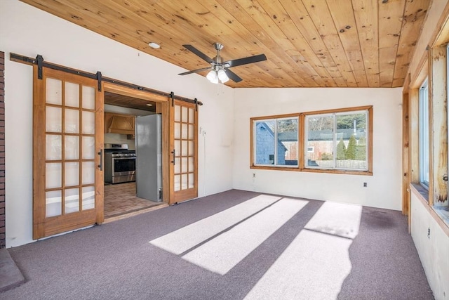 empty room with carpet floors, lofted ceiling, wooden ceiling, and a barn door