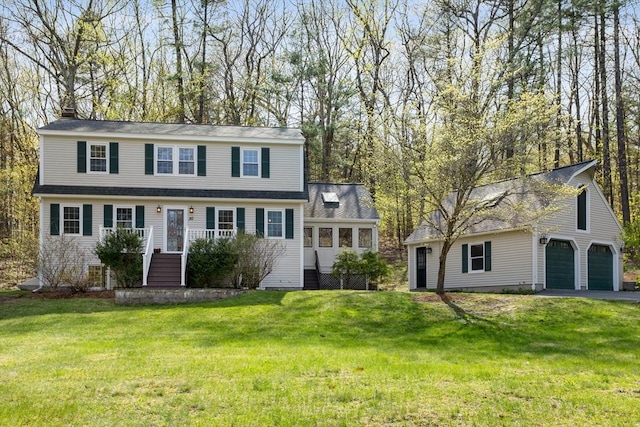 view of front facade with driveway, a chimney, a front lawn, and a garage