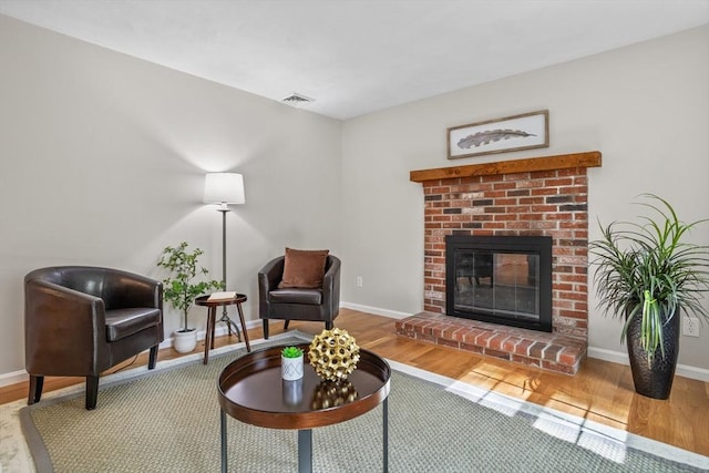living room with baseboards, a fireplace, and wood finished floors