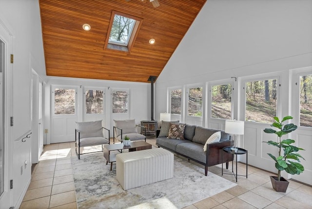 sunroom / solarium with tile patterned flooring, high vaulted ceiling, plenty of natural light, a skylight, and wood ceiling
