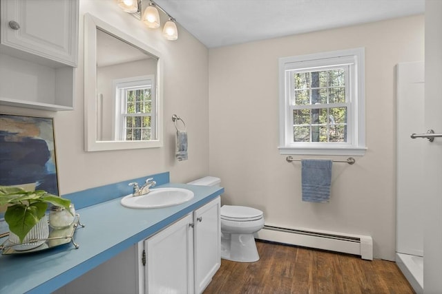 bathroom with vanity, a baseboard radiator, wood finished floors, and toilet