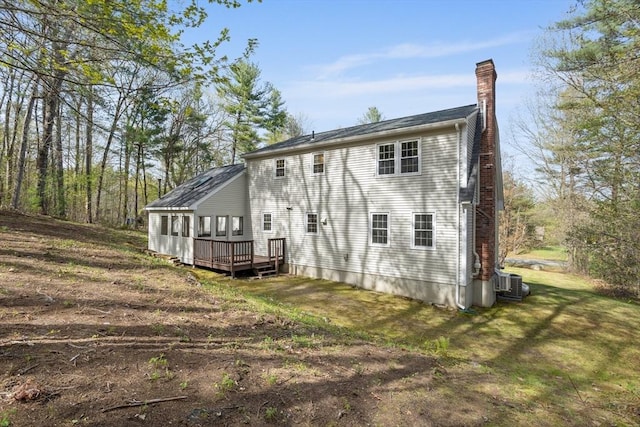 back of house with central AC unit, a chimney, and a deck