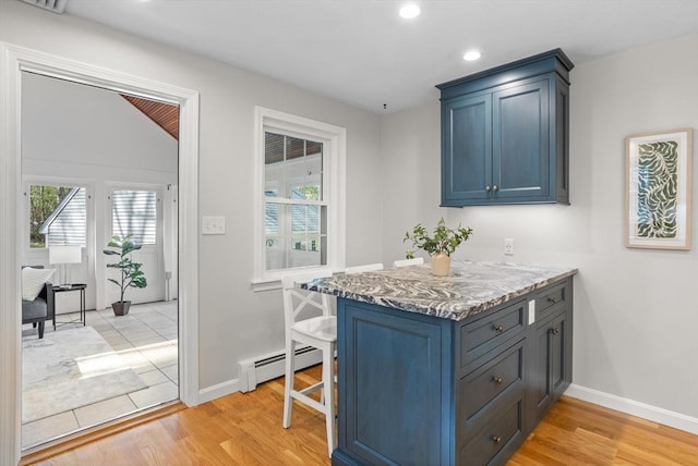 kitchen with baseboards, a baseboard heating unit, and light wood-type flooring