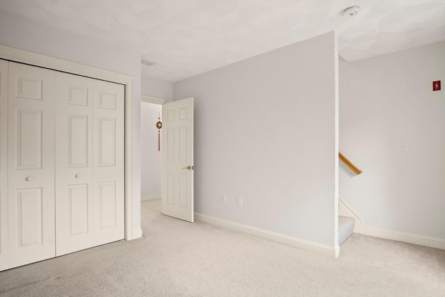 unfurnished bedroom with carpet floors, baseboards, and a closet