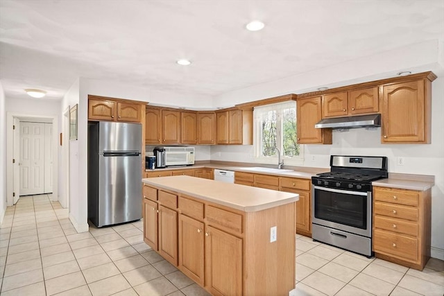 kitchen featuring appliances with stainless steel finishes, under cabinet range hood, a sink, light countertops, and light tile patterned floors
