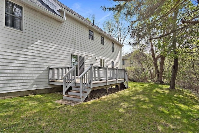 rear view of property with a wooden deck and a yard
