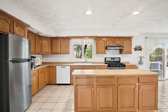 kitchen featuring stainless steel appliances, a sink, light tile patterned floors, light countertops, and recessed lighting