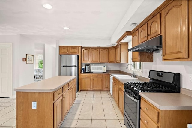kitchen featuring stainless steel appliances, a sink, under cabinet range hood, light tile patterned floors, and plenty of natural light