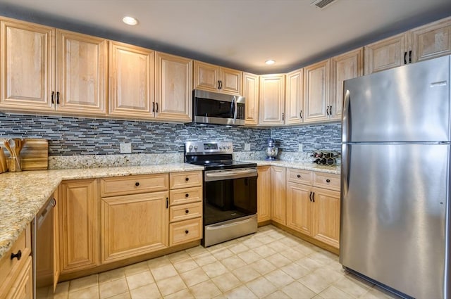 kitchen featuring backsplash, light brown cabinetry, appliances with stainless steel finishes, light tile patterned flooring, and light stone counters