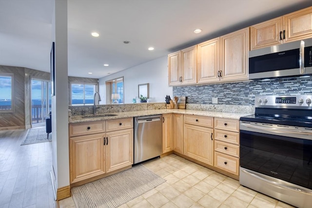 kitchen featuring light brown cabinets, light stone counters, sink, and appliances with stainless steel finishes