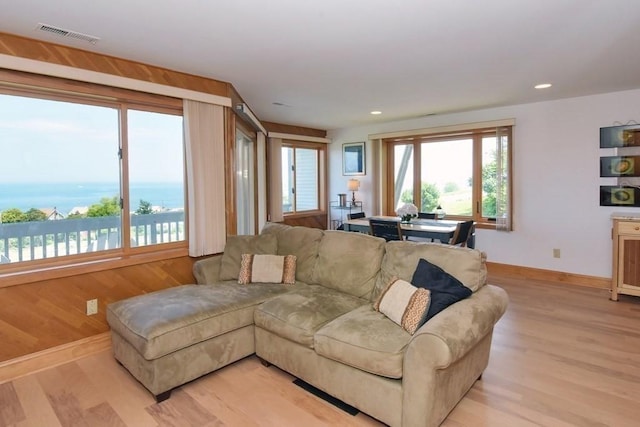 living room featuring a water view and light wood-type flooring