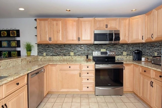 kitchen featuring light stone countertops, light brown cabinetry, tasteful backsplash, stainless steel appliances, and light tile patterned floors