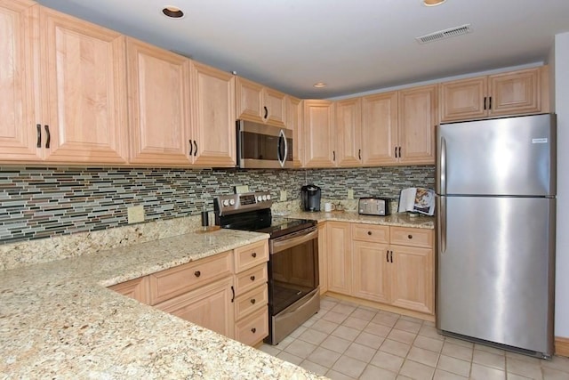 kitchen featuring light brown cabinets, backsplash, light stone countertops, light tile patterned floors, and appliances with stainless steel finishes