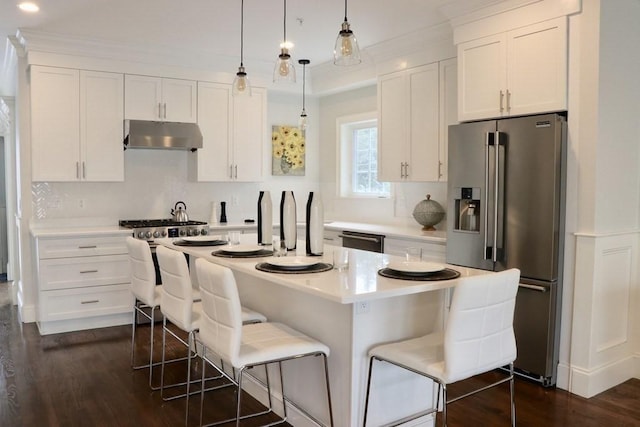 26 Dalby St, Newton, MA 02458 - kitchen with stainless steel appliances, under cabinet range hood, dark wood-style flooring, a breakfast bar, and recessed lighting
