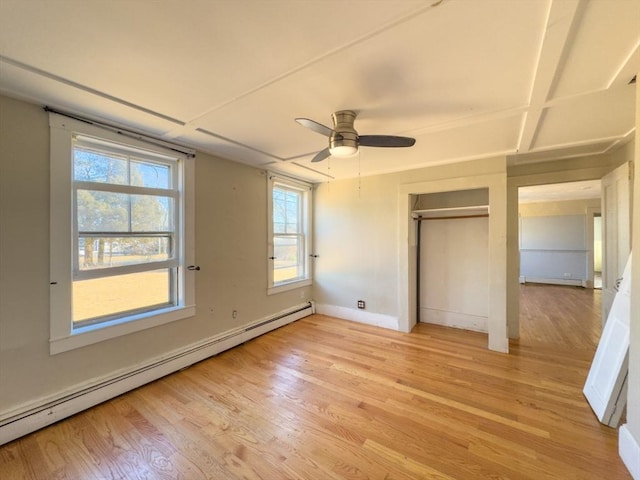 unfurnished bedroom with ceiling fan, a closet, light hardwood / wood-style flooring, and a baseboard heating unit