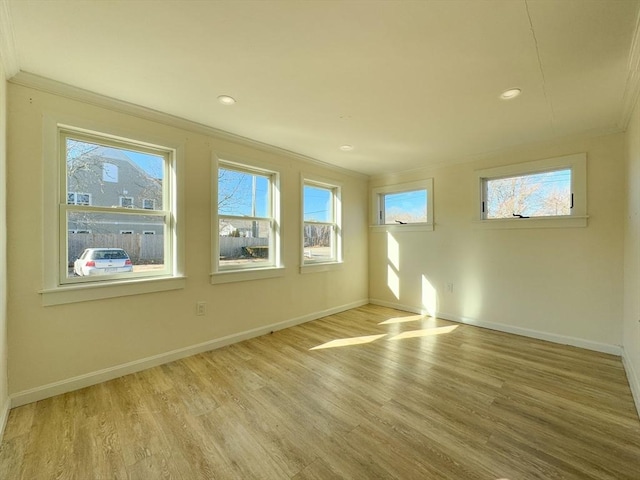 unfurnished room featuring ornamental molding and light wood-type flooring