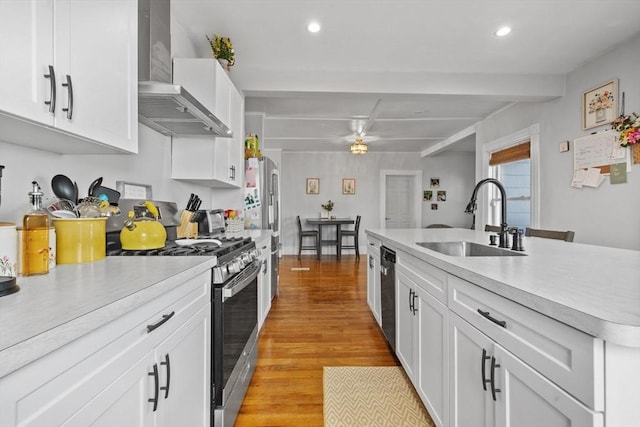 10 Atkins Ave, Lynn, MA 01904 - kitchen featuring stainless steel appliances, wall chimney exhaust hood, a sink, light wood-style floors, and light countertops
