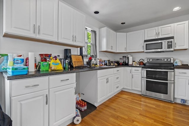 10 Atkins Ave, Lynn, MA 01904 - kitchen featuring stainless steel appliances, dark countertops, white cabinets, light wood-type flooring, and recessed lighting