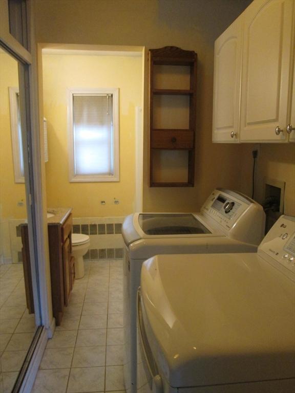 26 Horseshoe Dr Unit 26, Chicopee, MA 01022 - laundry room featuring washer and dryer, radiator heating unit, and light tile patterned flooring