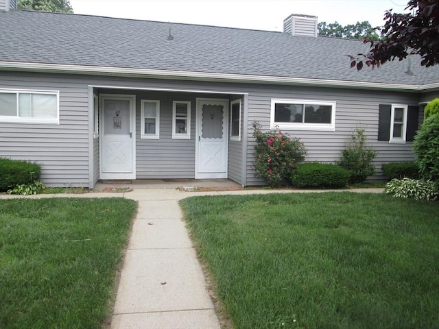 26 Horseshoe Dr Unit 26, Chicopee, MA 01022 - view of front of house with a chimney, a front lawn, and a shingled roof