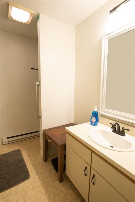 bathroom with a baseboard radiator, vanity, and tile patterned floors