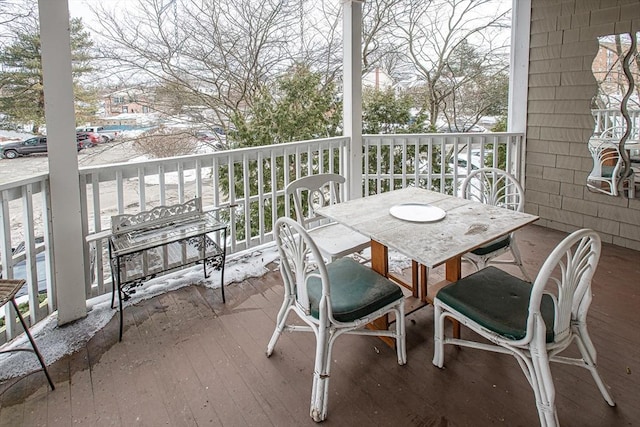 snow covered back of property with outdoor dining area