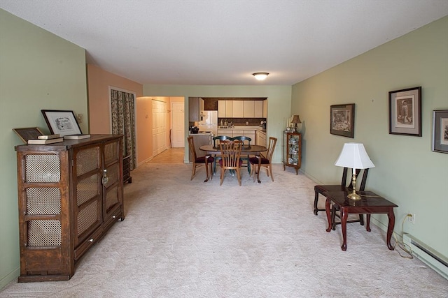 dining area featuring baseboards, a baseboard heating unit, and light colored carpet