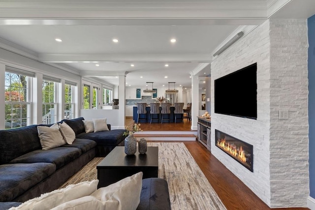 8 Whispering Hill Rd, Woburn, MA 01801 - living room featuring a healthy amount of sunlight, beamed ceiling, a stone fireplace, and dark wood-style floors