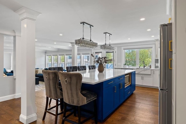 8 Whispering Hill Rd, Woburn, MA 01801 - kitchen featuring stainless steel appliances, open floor plan, ornate columns, and blue cabinetry