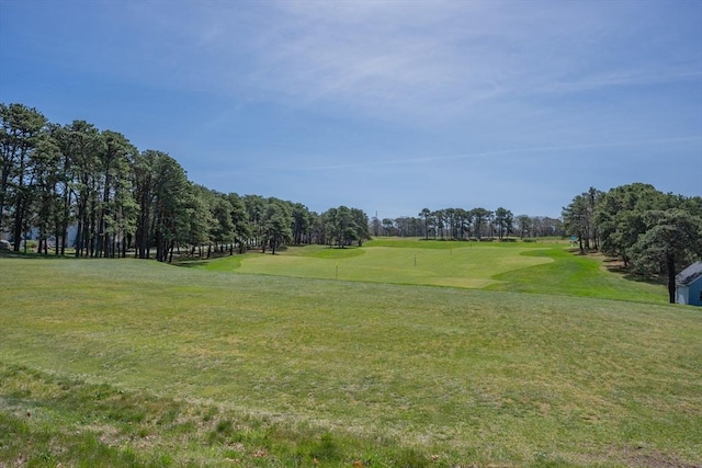 view of property's community featuring golf course view and a yard