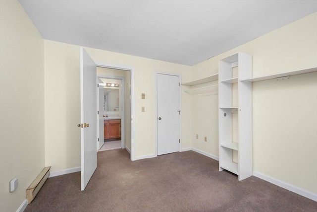 unfurnished bedroom with carpet floors, baseboards, and baseboard heating